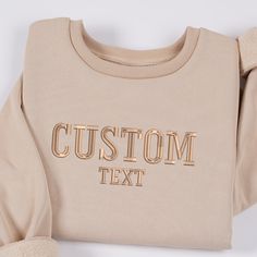 a beige sweatshirt with the words custom text on it