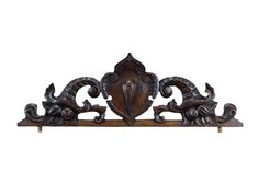 an ornate wooden shelf with carved designs on the top and bottom, against a white background