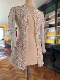 "A beautifully made Battenberg lace jacket made by C.E Smith, Spitalfields, London. There are no seams on this jacket, woven to form. Has puff sleeves with a wide pointed cuff There is a flared lower back and rounded and scalloped shape at the front. In excellent condition.  This has been part of a collection held by the one owner in the UK.  There are no closures Size 10-12 Bust - lace meet at centre front on 37\" bust  Waist 34\" Hips free due to flare  Length 29\"" Elegant Fitted Cardigan With Lace Trim, Fitted Lace Cardigan For Party, Elegant Fitted Lace Trim Cardigan, Elegant Party Outerwear With Lace Trim, Elegant Delicate Lace Top For Fall, Fitted Formal Outerwear With Lace Trim, Formal Fitted Outerwear With Lace Trim, Formal Fitted Lace Outerwear, Fitted Scalloped Lace For Ceremony