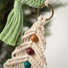 an ornament hanging from a tree with beads and tassels