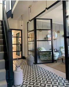 an instagram photo of a living room with stairs and glass doors that lead up to the second floor