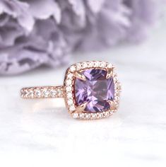 Gorgeous Classic Cushion Cut Ceylon Purple Sapphire Ring ►Base Metal: Sterling Silver (925) ►Plating: 14K Rose Gold ►Accented with simulated diamonds (CZ) ►Average band width: 1.9 mm Center Stone: Sapphire Color: Purple Gemstone Creation: 100% Genuine Lab-Grown Sapphire Stone Cut: Cushion Size: 8.0 x 8.0 mm Carat Weight: 2.5 ct. (approx.) Hardness: 9 (Mohs scale) ►Please be aware that plated jewelry can wear off over time, if this is a concern we would suggest going with the sterling silver or s Unique Gemstone Engagement Rings, Morganite Engagement Ring Oval, Ceylon Sapphire Ring, Purple Sapphire Ring, Mohs Scale, Rose Gold Accents, Purple Sapphire, Sapphire Color, Birthstone Gifts