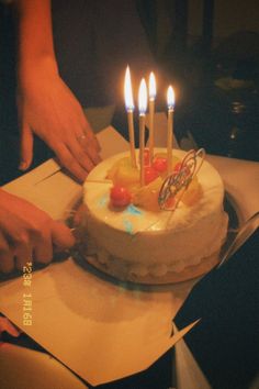 someone cutting into a cake with candles on it