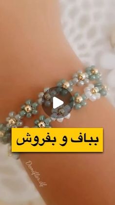 a woman's bracelet with pearls and beads on it, in arabic text that reads