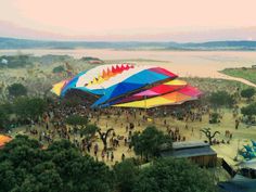 an aerial view of a festival with large colorful tents and people standing around the tent