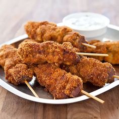 chicken skewers on a plate with dipping sauce