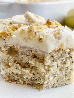 a close up of a piece of cake on a plate with bananas in the background