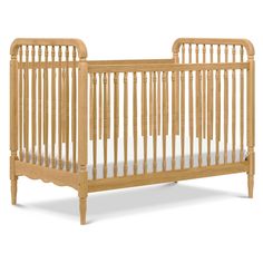 a wooden crib with white sheets on the bottom and side rails, against a white background