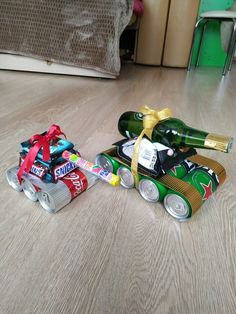 two soda cans are laying on the floor next to each other and one has a wine bottle in it