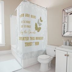 a bathroom with a shower curtain that says you are here