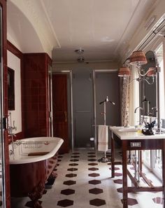 an old fashioned bathtub and sink in a bathroom with black and white floor tiles