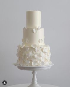 a three tiered cake with white flowers on top