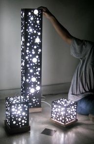 a man kneeling down next to three lit up cubes