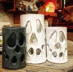 three ceramic cups sitting on top of a wooden table