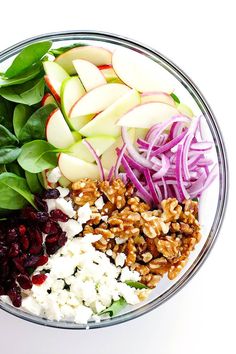 apples, cranberries, walnuts and spinach salad in a glass bowl