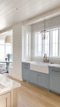 a large kitchen with blue cabinets and white counter tops is pictured in this image from the inside