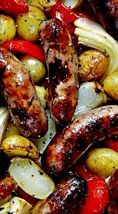 sausages, onions, and potatoes are being cooked on the grill