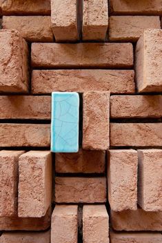 a square blue object sitting on top of a pile of bricks