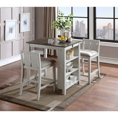 a kitchen table with two chairs next to it and a vase filled with lemons