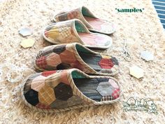 three pairs of slippers sitting on top of a carpet covered in patches of fabric