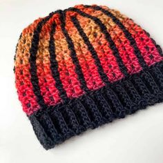 a multicolored knitted hat sitting on top of a white table