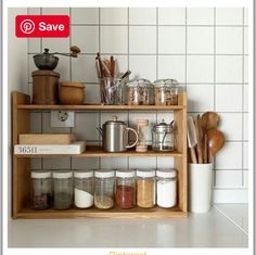 a shelf filled with lots of different types of spices on top of a tiled wall