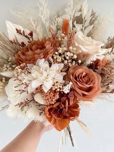 a bridal bouquet is being held by someone's hand