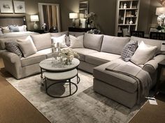 a living room filled with lots of furniture next to a white coffee table and couch