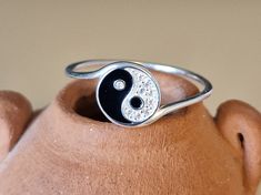 This tiny delicate ring is a beautifully crafted sterling silver piece, one centimeter in diameter, showcasing a unique interpretation of the Yin Yang symbol.  The delightful black and white design decorated with over 9 tiny crystals makes an ideal gift or treat yourself. This distinctive pendant is a harmonious blend of natural beauty and artistic design, making it a standout accessory.  MATCHING NECKLACE HERE: https://www.etsy.com/uk/listing/1660404741/tiny-ying-yang-crystal-sterling-silver?cl Nickel Free Symbolic Stackable Rings As Gift, Adjustable Symbolic Stackable Rings As Gift, Adjustable Symbolic Stackable Rings For Gift, Symbolic Sterling Silver Stackable Rings, Hypoallergenic Symbolic Round Jewelry, Adjustable Stackable Circle Rings As Gift, Symbolic Stackable Gift Rings, Symbolic Sterling Silver Stackable Rings For Anniversary, Silver Round Rings