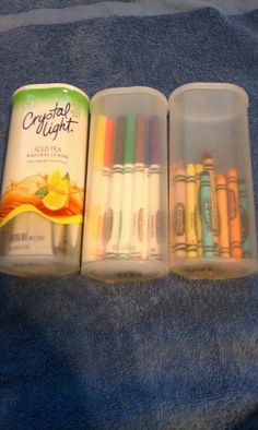 three plastic containers filled with crayons on top of a blue carpeted floor