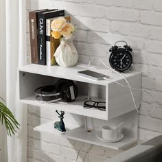 a white shelf with some books and headphones on it