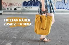 a woman carrying a yellow bag with the words totebag nahen zusatz - tutor