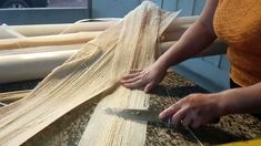 a woman is using a pair of scissors to cut up fabric on a table top