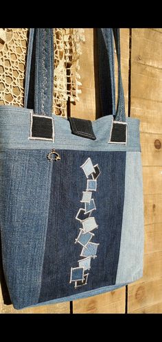 a handbag made out of jeans with an embroidered design on the front and sides