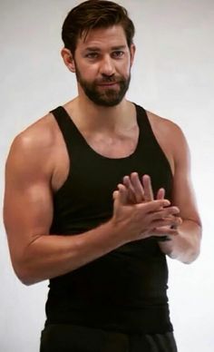 a man in black tank top holding his hands together