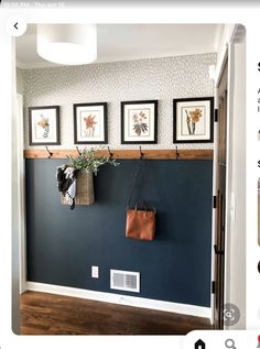 a blue wall with three pictures on the wall and a purse hanging from it's hooks