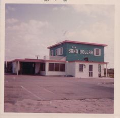 the sand dollar building is green and white with red trim on it's roof