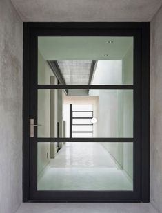 an empty hallway with glass doors and white walls