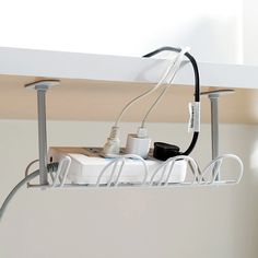 an electronic device is connected to wires and plugs on a shelf above a sink