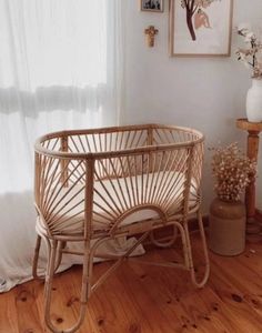 a baby crib sitting on top of a hard wood floor next to a window