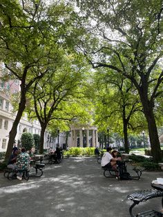 people are sitting on benches in the park