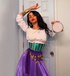 a woman in a purple and green costume holding a tennis racquet while standing next to a door