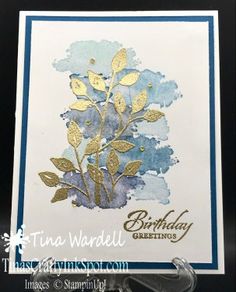 a handmade birthday card with gold foil flowers on blue watercolor paper and the words, happy birthday