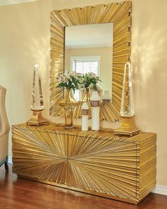 a gold sideboard with vases and candles on it