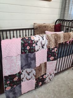 a baby crib with a quilted blanket on it's side and pillows in the back