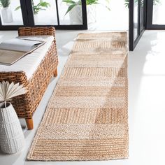 a living room with wicker furniture and large windows