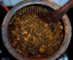 a wooden spoon in a pot filled with food