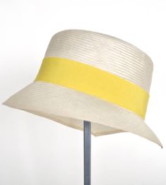 "\"Kami\" is pure elegance. The handmade hat is available in the high-quality \"parasisol\" with a lemmon yellow coloured hatband. Available in sizes 55 cm - 58 cm. Colour \"natur\" with a lemmon yellow coloured hatband and black accent Parasol hat (plaited straw) 66% cotton and 34% polyamide on the inside Ribbon of cotton and viscose Handmade Individualization options Other colours or sizes on request. All hats are handmade. For the production of a perfect hat it takes some time. All hats are r Toquilla Straw Bucket Hat For Kentucky Derby, Kentucky Derby Toquilla Straw Bucket Hat, Cream Flat Brim Top Hat For Summer, Summer Bucket Hat In Toquilla Straw With Short Brim, Elegant Natural Straw Hat Bands, Elegant Adjustable Bucket Hat For Summer, Elegant Cream Panama Hat Made Of Straw, Elegant Cream Panama Hat In Straw, Elegant Cream Straw Panama Hat