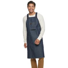 a man wearing an apron and smiling at the camera with his hands in his pockets