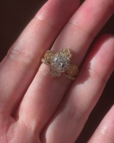 a close up of a person's hand with a gold ring on it and a diamond in the middle